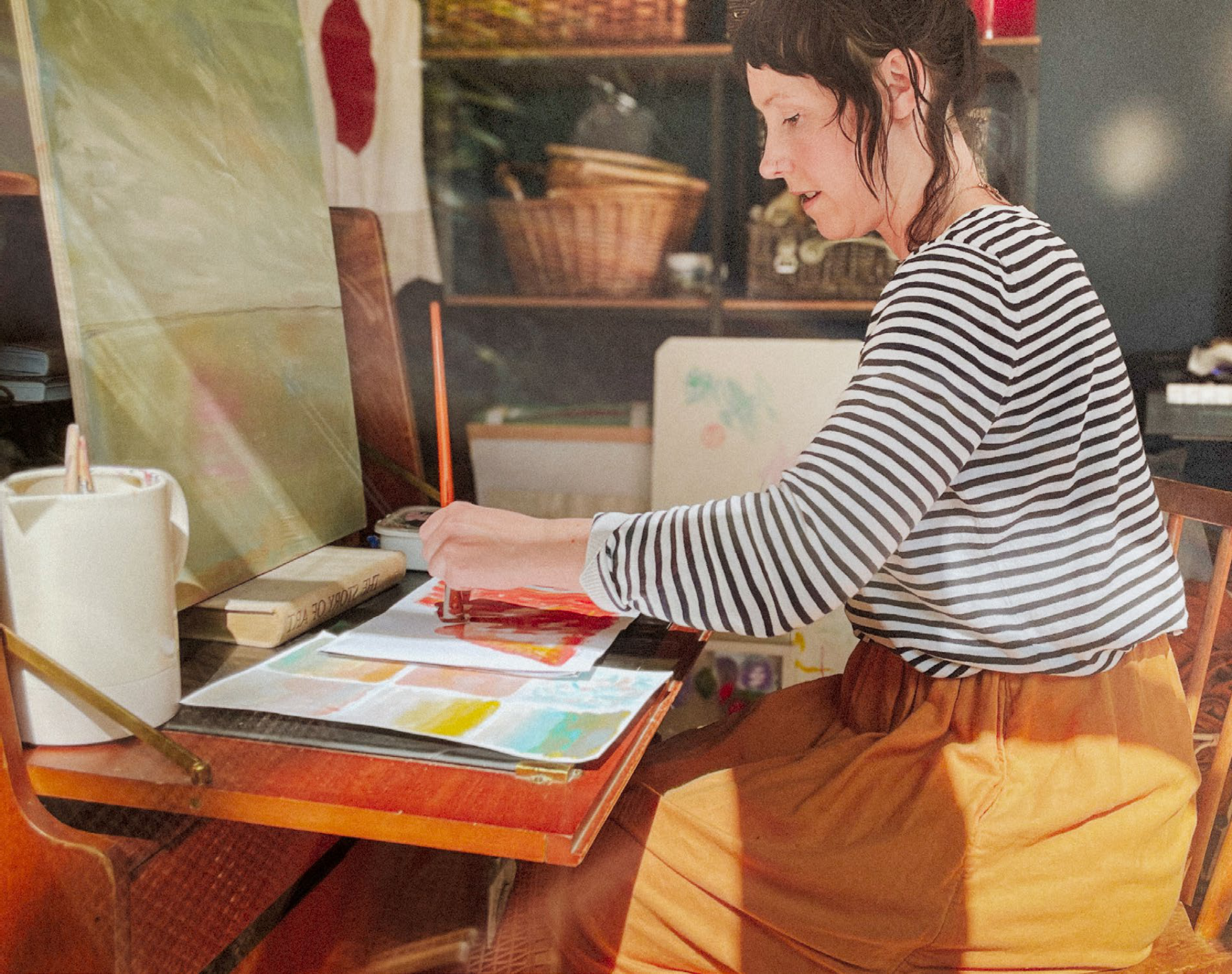 Eilidh sitting at a desk painting swatches